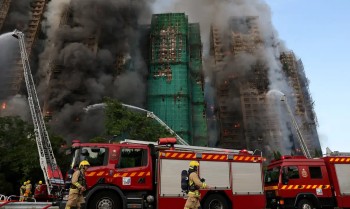 Pessoas se reúnem em local de incêndio em Hong Kong