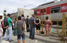 Pedestres pedem passarela com escada rolante em praça