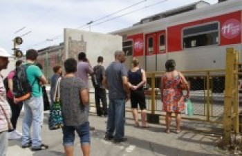 Pedestres pedem passarela com escada rolante em praça